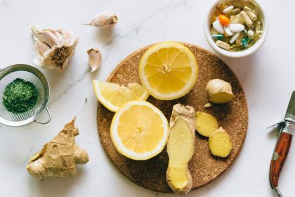Flat lay of natural remedies including lemon, ginger, and garlic alongside pills.