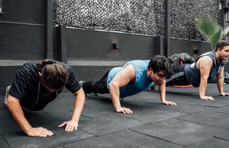 Men performing push-ups during a group workout session in Mexico City gym.